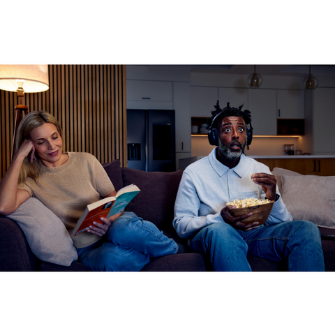 Sennheiser RS 275 TV Headphones with BTA1 Auracast Transmitter man eating popcorn wearing headphones (view 8 of 8)